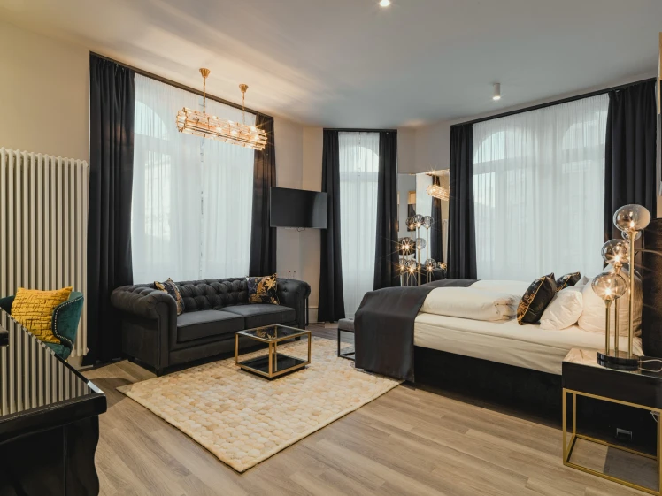 Superior Room at BS Boutique Hotel Heidelberg. With a black bed, black sofa, and white curtains in the hotel room.